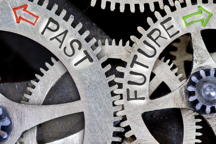 Macro photo of tooth wheel mechanism with arrows and PAST, FUTURE letters