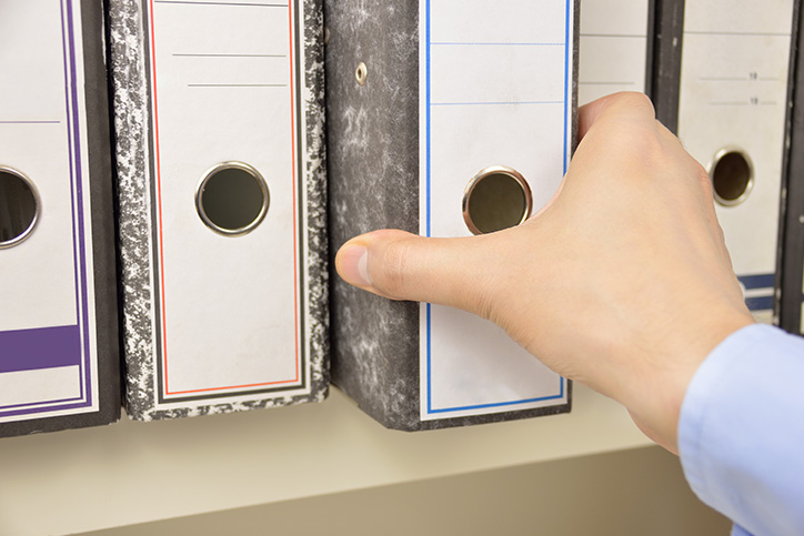 man pulling out a file folder