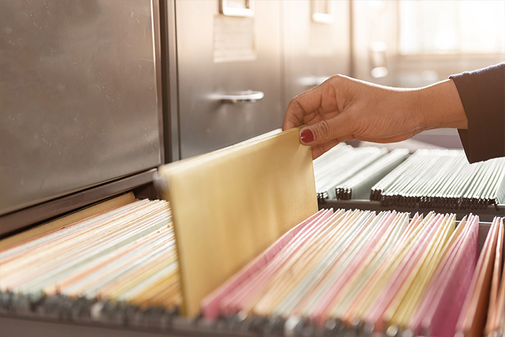 woman pulling out file folder from file cabinet